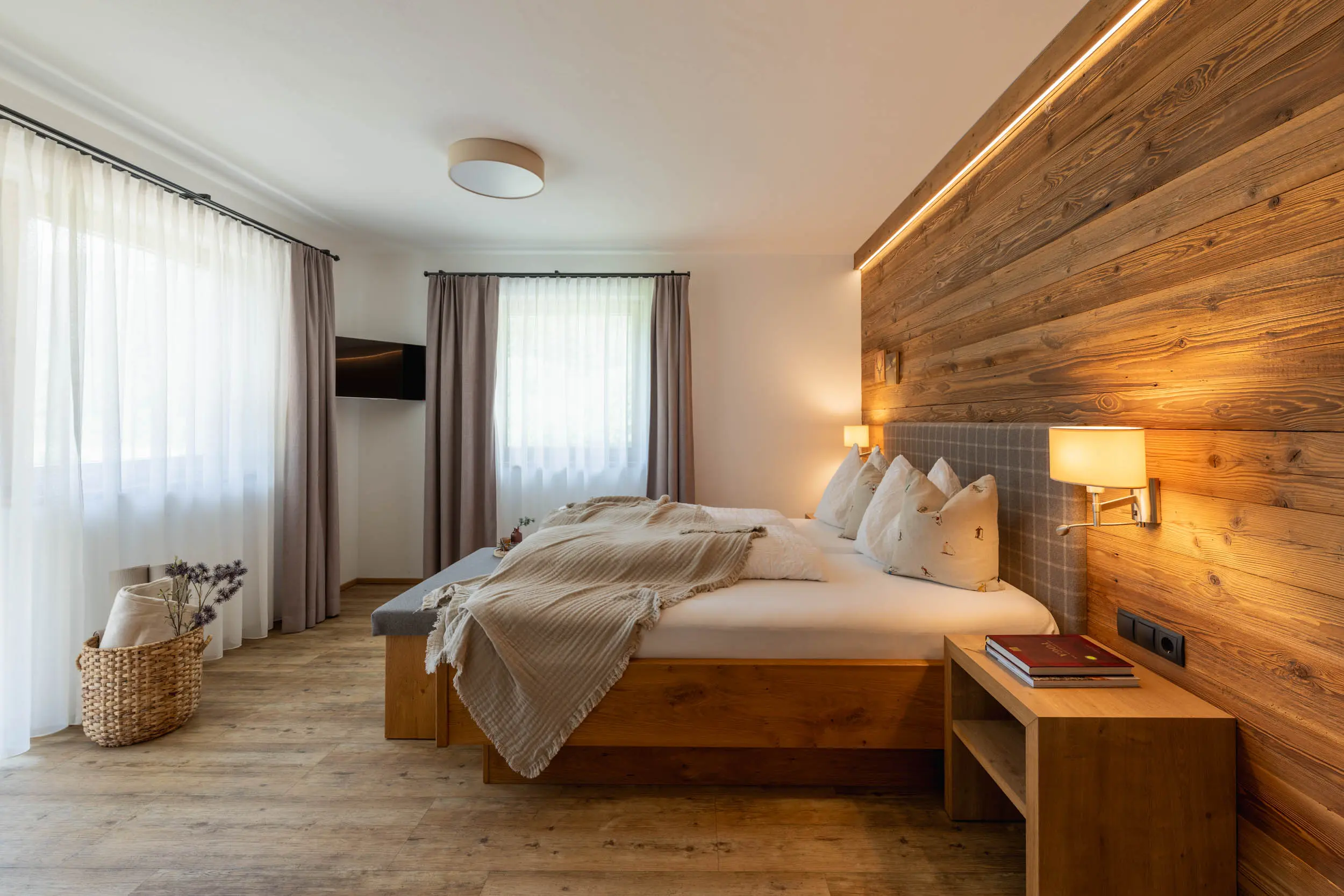 Schlafzimmer mit Holzwand und Fenster im stoanmandl Appartement