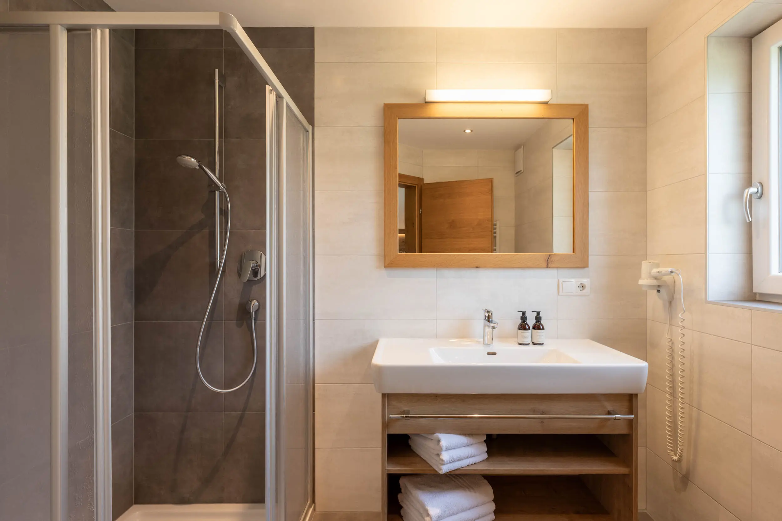 Badezimmer mit Dusche und Spiegel im stoanmandl Appartement