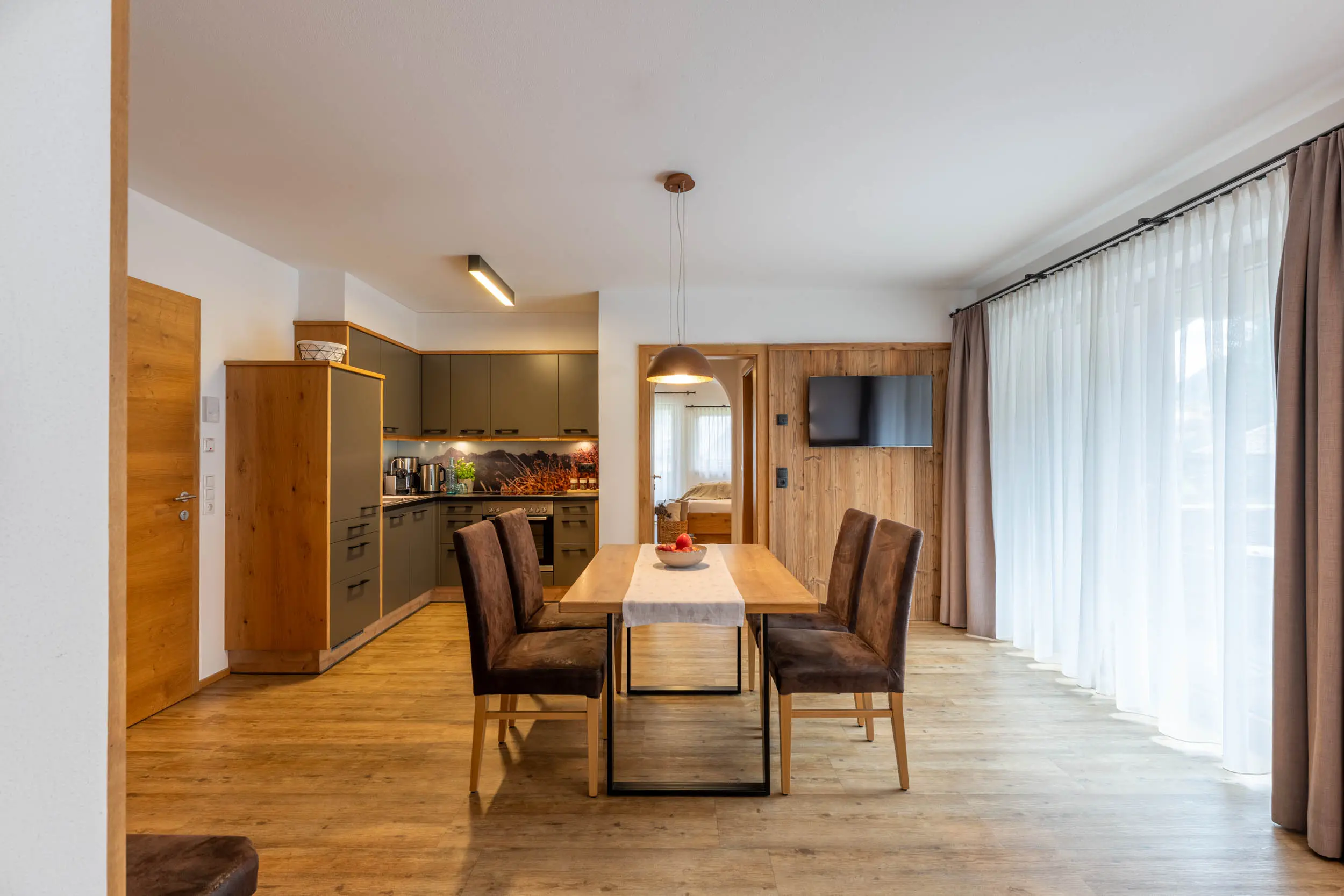Wohnbereich mit Blick auf Balkon und Berge, stoanmandl Appartement