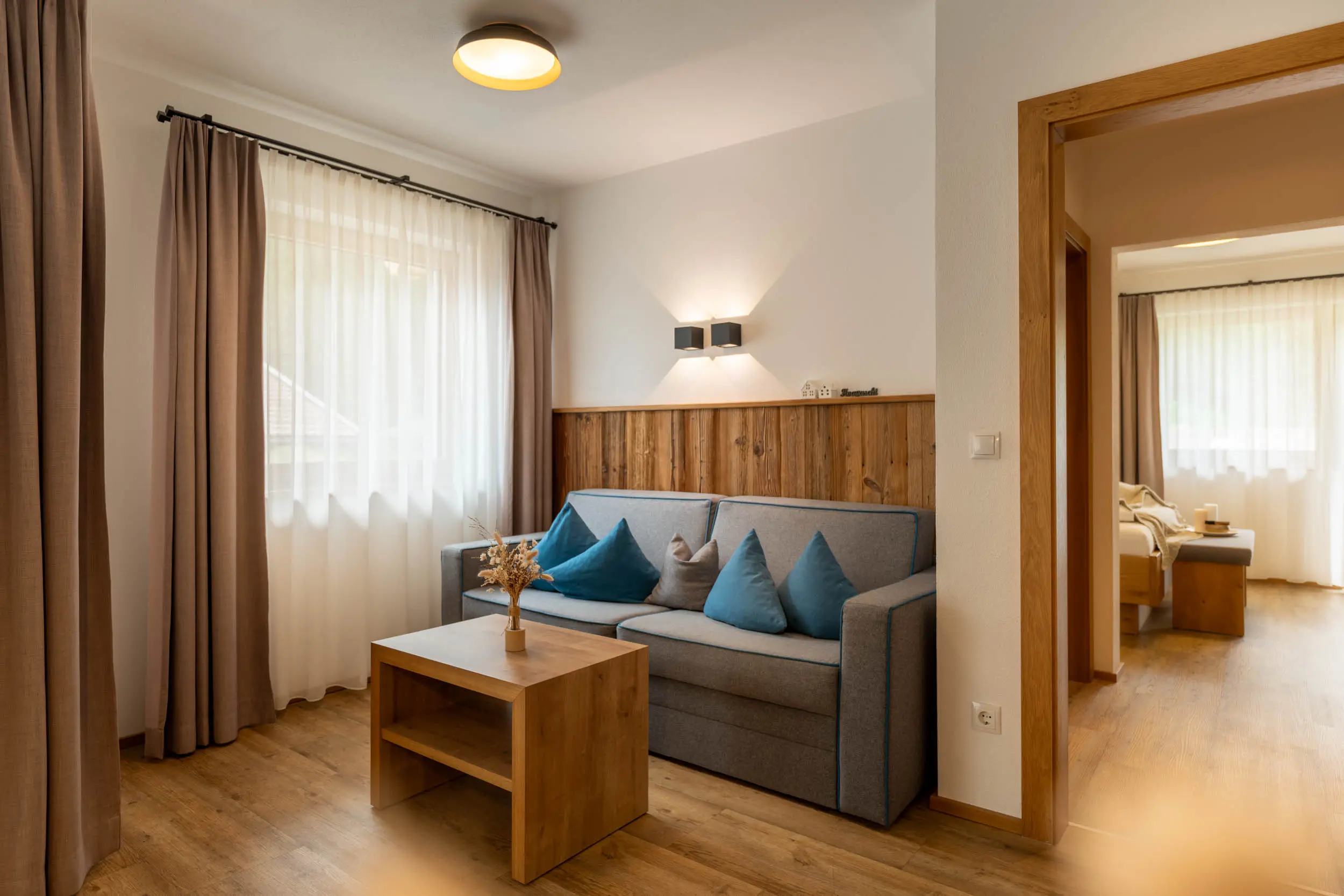 andreschoenherr__NZ81133-HDR Wohnraum mit Sofa und Essbereich im stoanmandl Appartement
