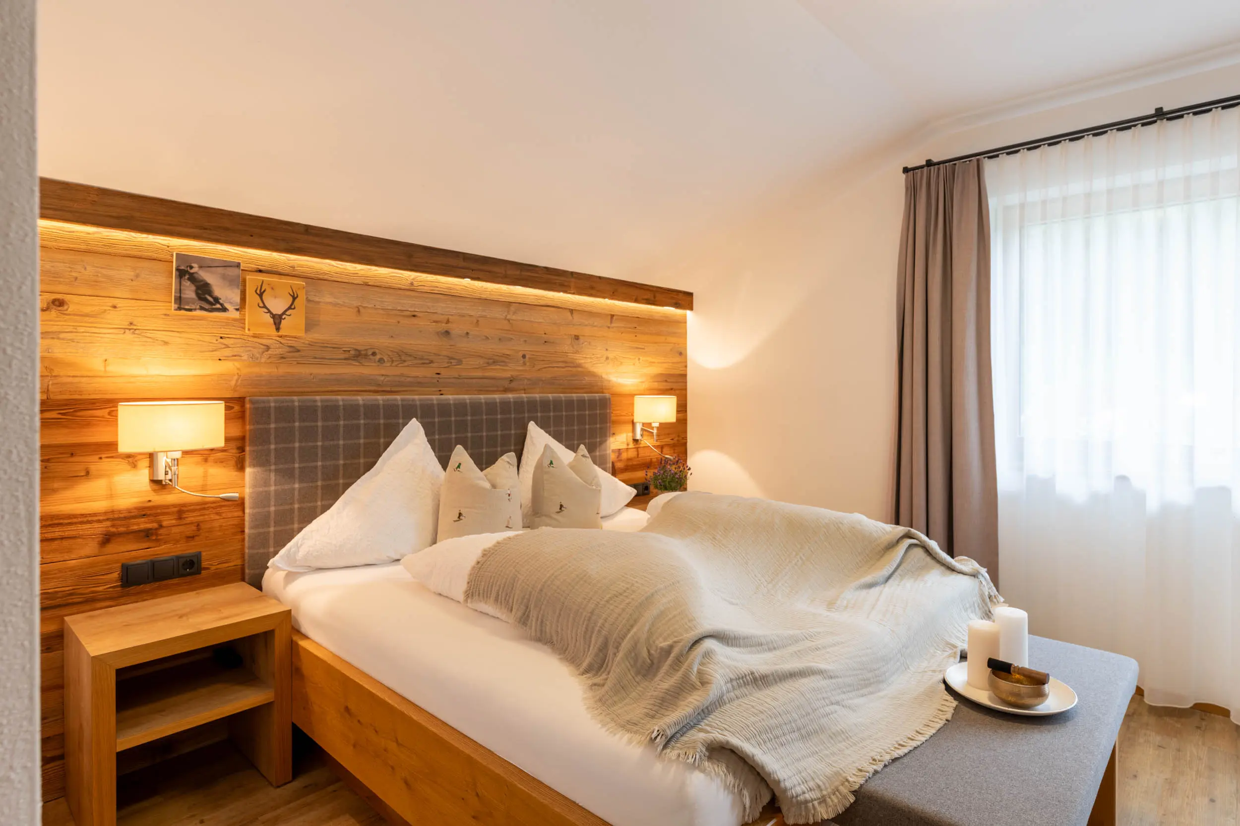 Helles Schlafzimmer mit Holzwand im 6er Appartement, stoanmandl